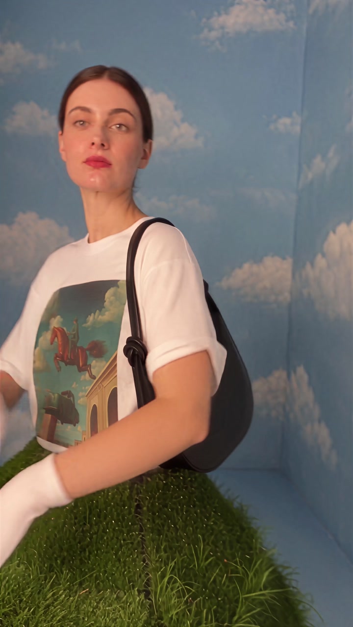The presenter wearing the black Mini Rosetta Shoulder Bag in the personalized Reformation video